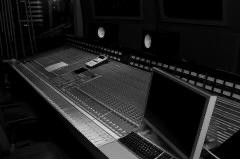 Black-and-white photo of a large analog mixing console in the studio